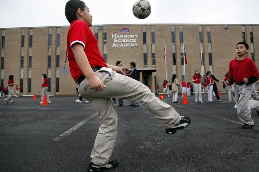 Fourth-grader Hayner Rodriguez plays soccer with his classmates on the blacktop parking lot...