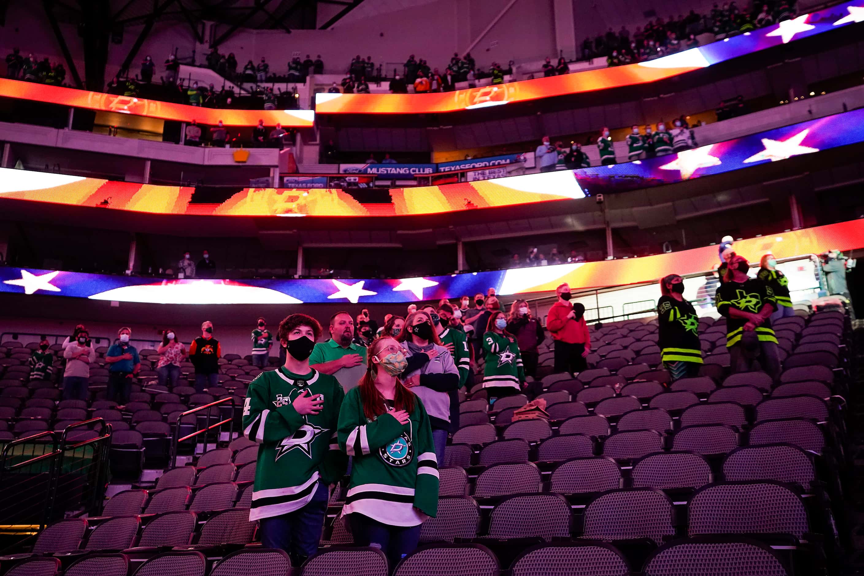 Dallas Stars fans stand for the national anthem before an NHL hockey game against the Tampa...