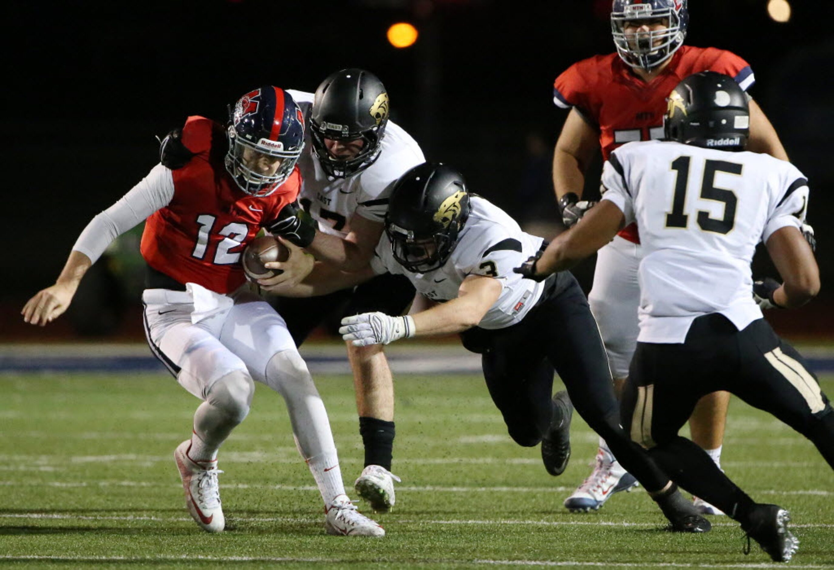 Plano East defensive end Michael McNair (17) and linebacker Will Garrey (3) sack McKinney...