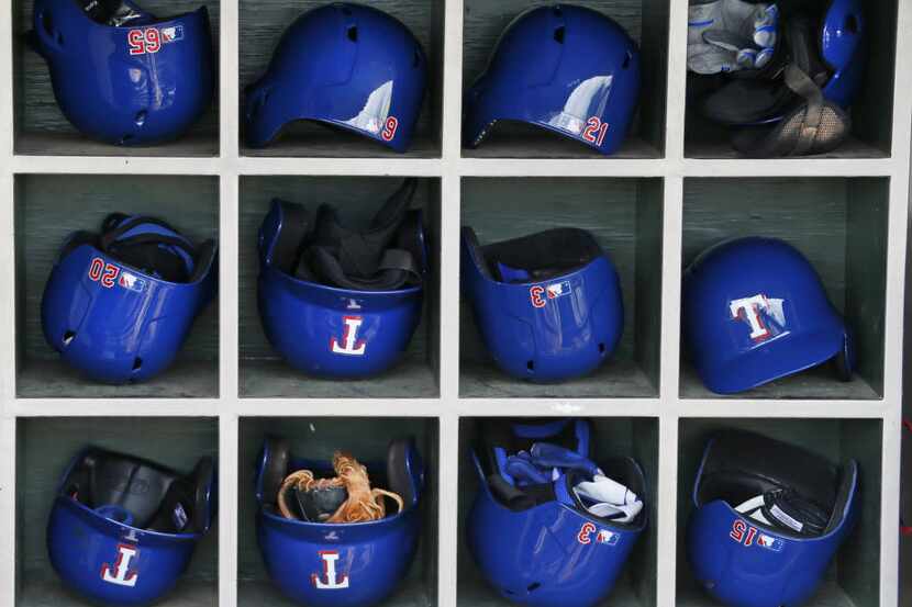 The Rangers helmets sit ready for action in the dugout before the Texas Rangers vs. the...