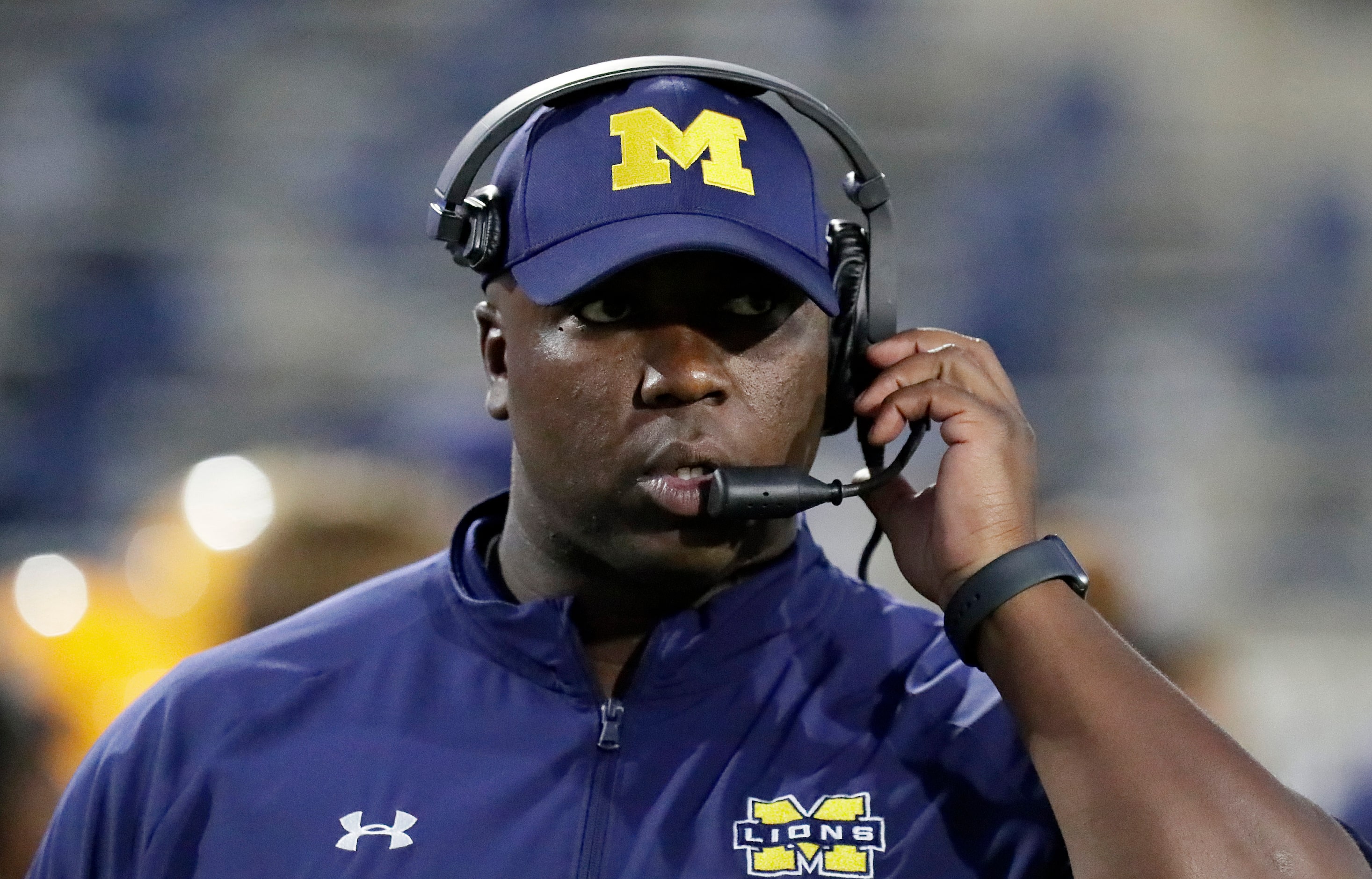 McKinney High School head coach Marcus Shavers talks to his coaches in the press box as...