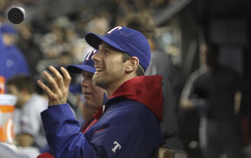 Texas Rangers P Cliff Lee plays catch with a smokeless tobacco can in the dugout during ALCS...