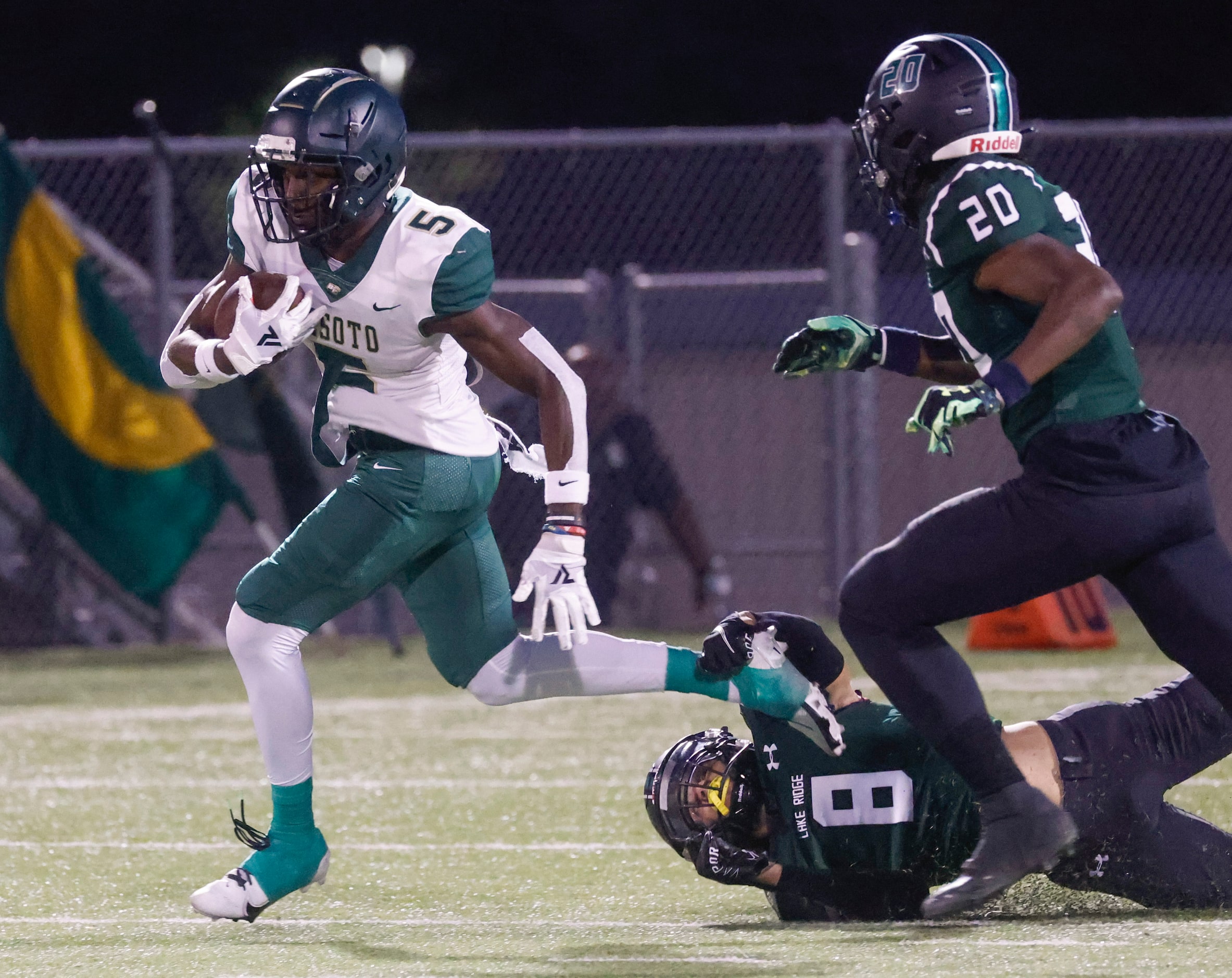 DeSoto High School’s Tre Wisner (5) runs past Lake Ridge High School’s Major Spencer (8) and...