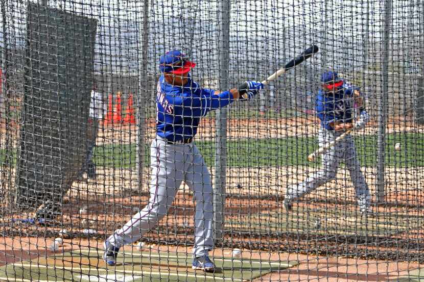 Texas infielder Luis Sardinas, left, and outfielder Michael Choice hit in the cages during...