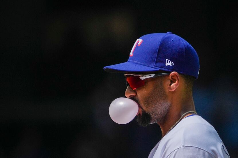 Texas Rangers second baseman Marcus Semien blows a bubble between pitches during the first...