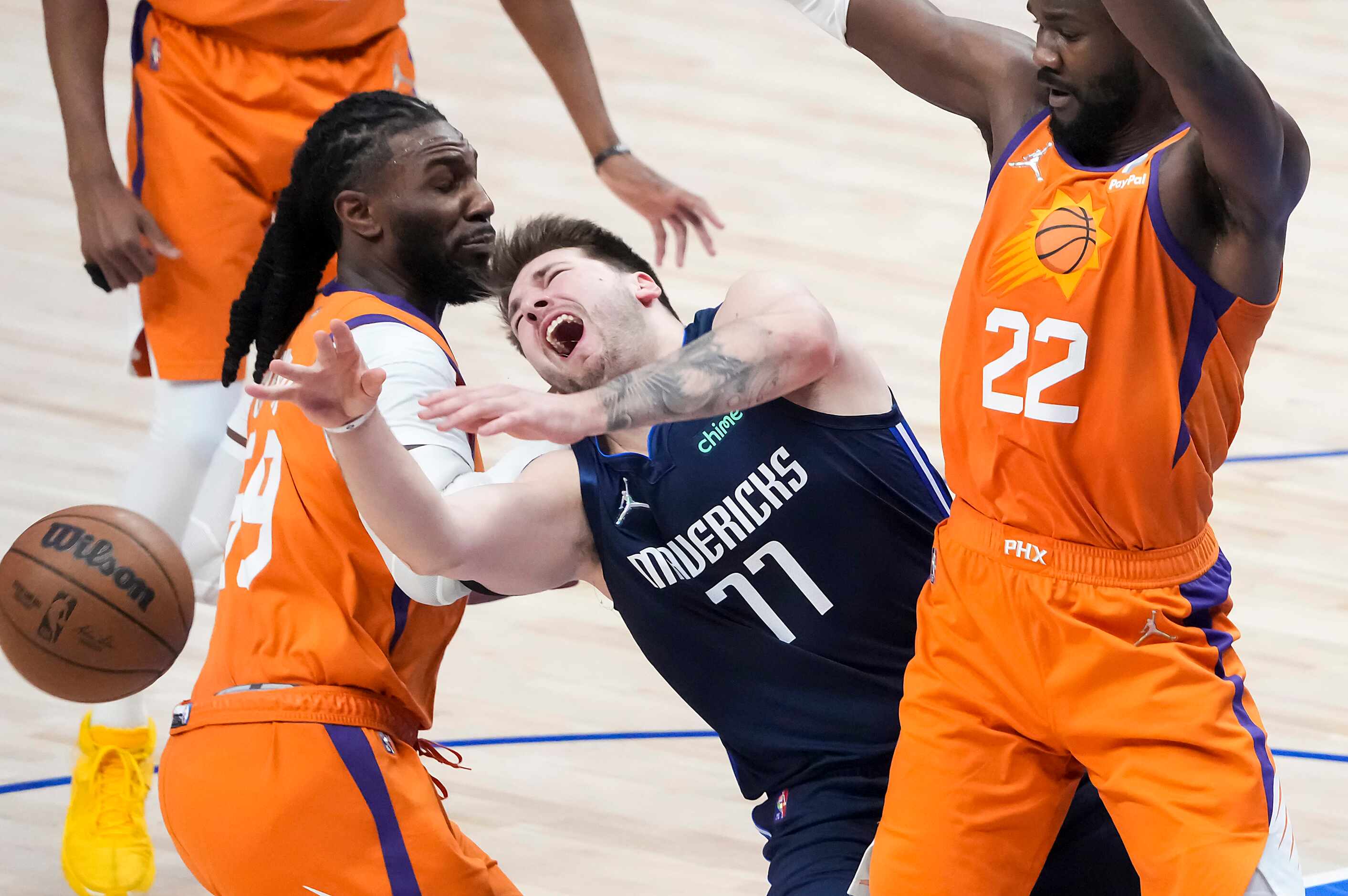 Dallas Mavericks guard Luka Doncic (77) loses the ball as he tries to drive between Phoenix...