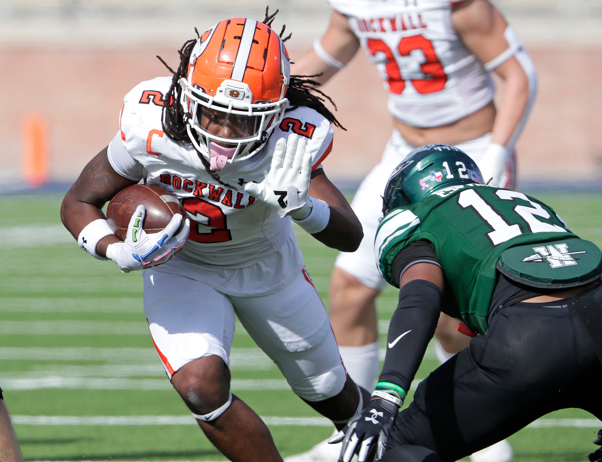 Rockwall High School running back Ashten Emory (2) prepares to stiff arm Waxahachie High...