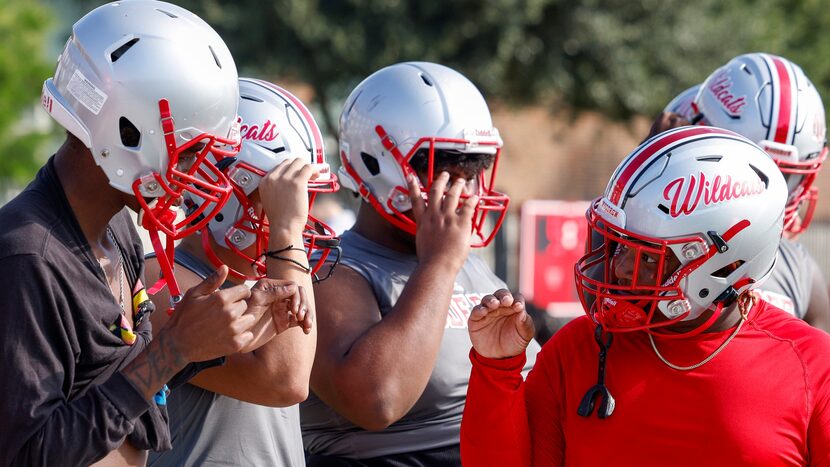 Arnaz Reese signs with a teammate during practice at Woodrow Wilson High School Monday,...