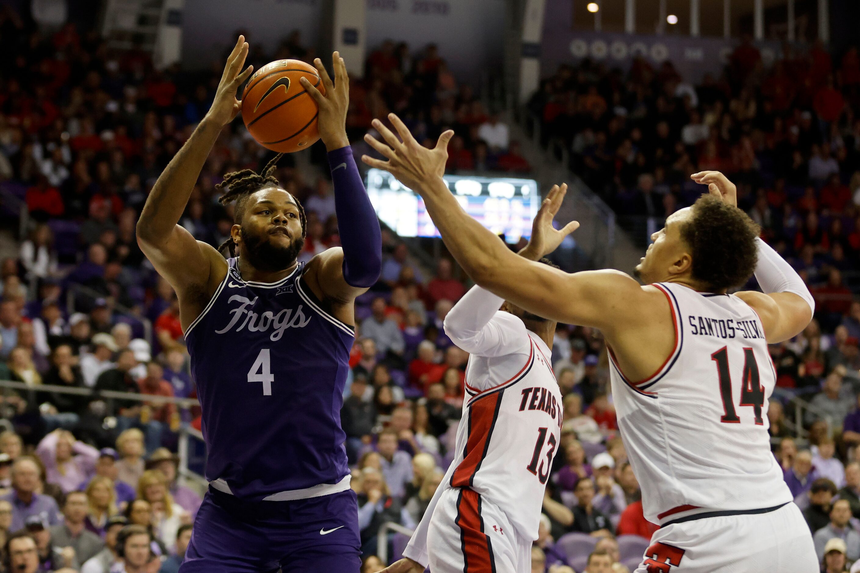 TCU center Eddie Lampkin (4) grabs a rebound in front of Texas Tech guard Mylik Wilson (13)...