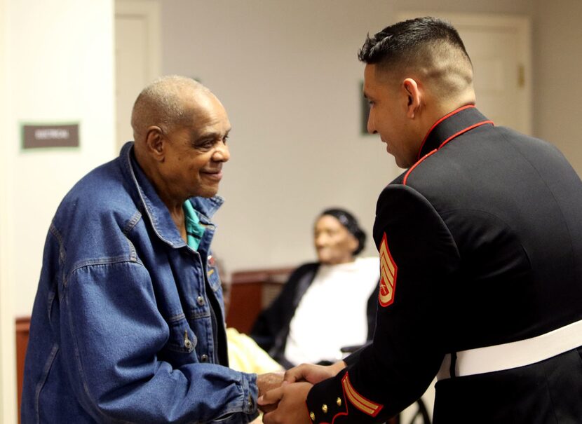 Sam Johnson, a U.S. Army veteran who fought in World War II, shakes Marine Corps Staff Sgt....