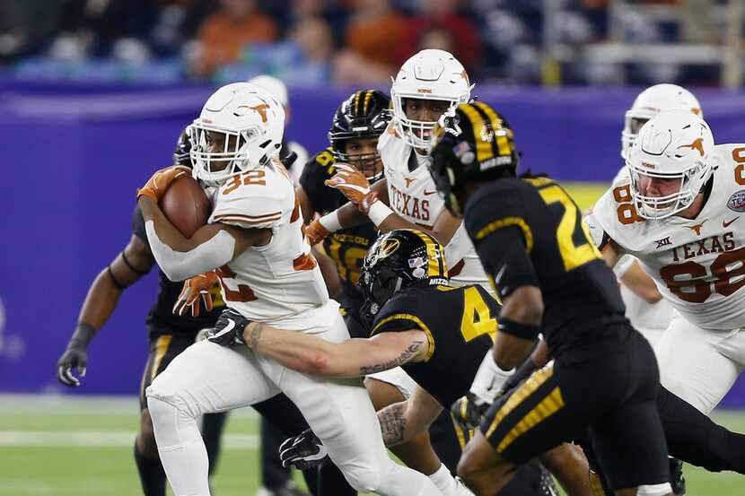 HOUSTON, TX - DECEMBER 27:  Daniel Young #32 of the Texas Longhorns rushes with the balll as...