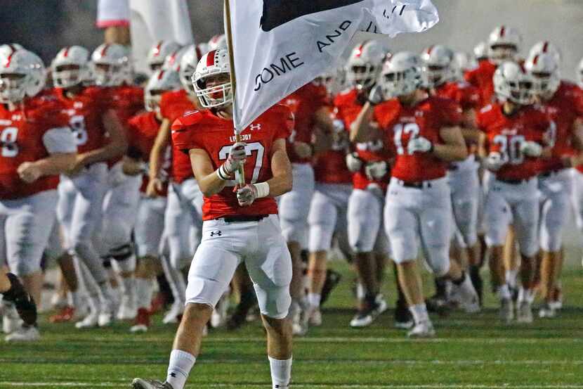 Lovejoy's Quinn Mcdermott carries the "Come and Take It" flag onto the field before kickoff...