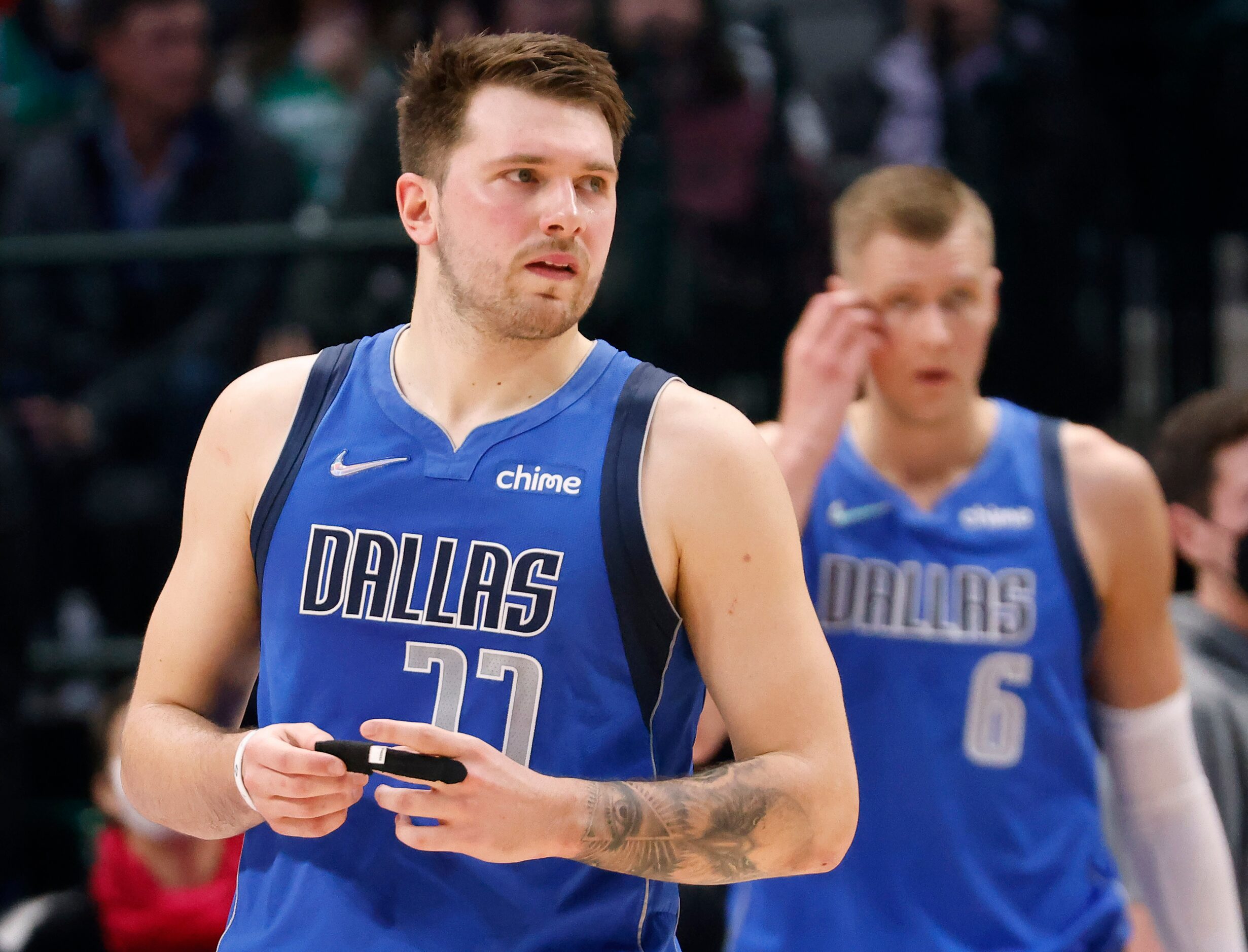 Dallas Mavericks guard Luka Doncic (77) adjusts the bandage on his index finger during the...