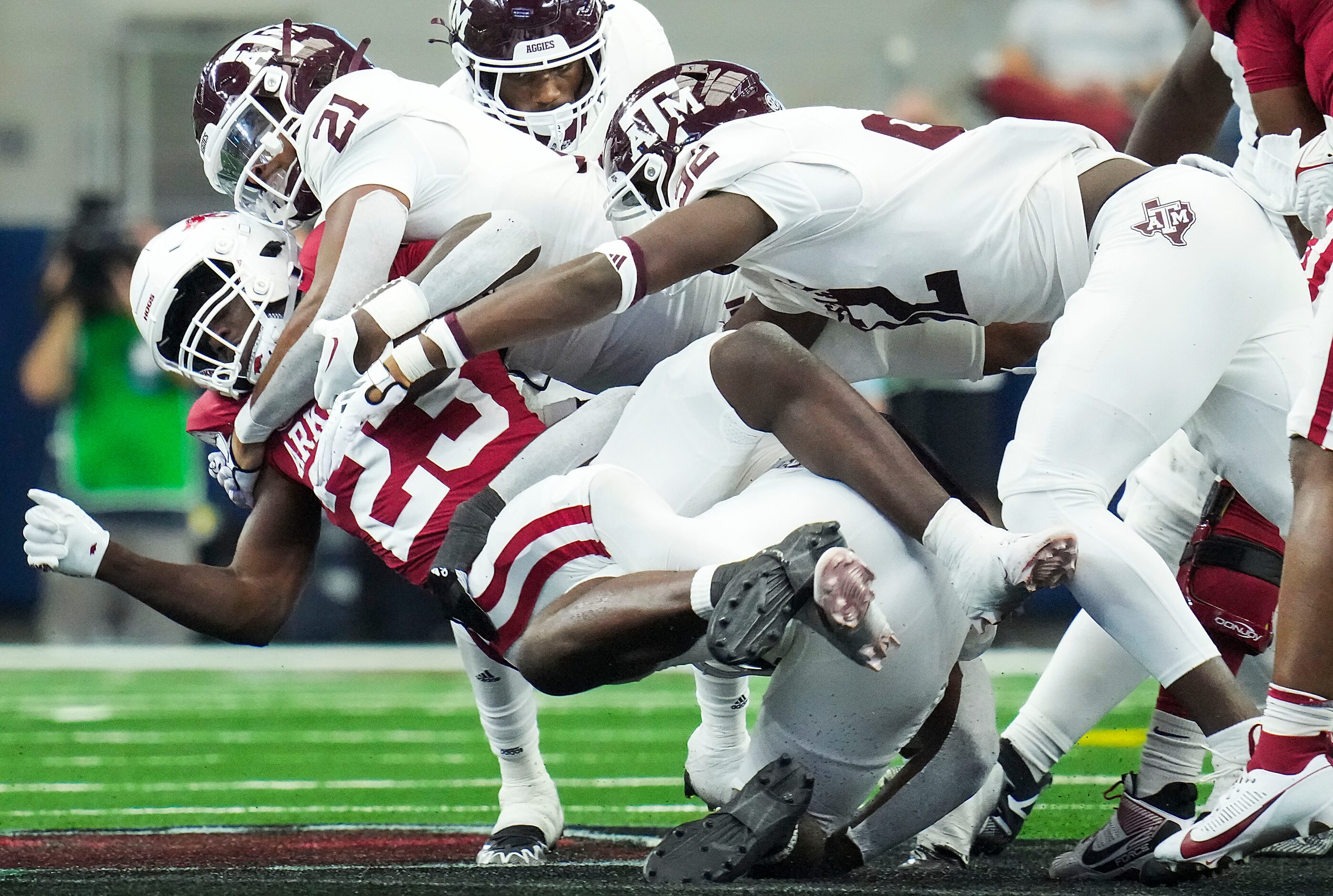 Arkansas running back Isaiah Augustave (23) is brought down by Texas A&M linebacker Taurean...