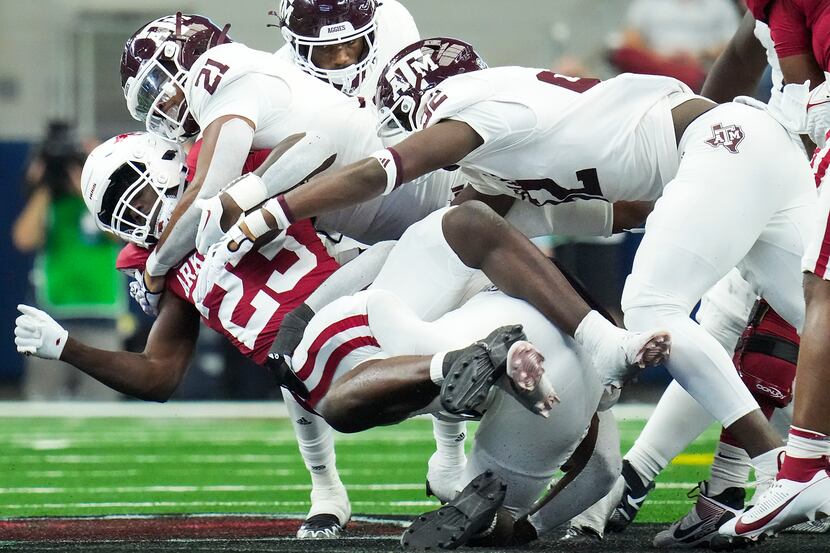Arkansas running back Isaiah Augustave (23) is brought down by Texas A&M linebacker Taurean...