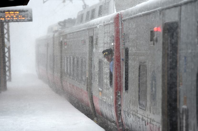 A train conductorlooks at the snow at the Metro North Greenwich train station on February 9,...