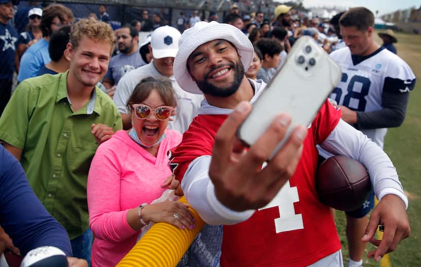 Dallas Cowboys quarterback Dak Prescott (4) grabbed a fan’s phone and takes a selfie with...