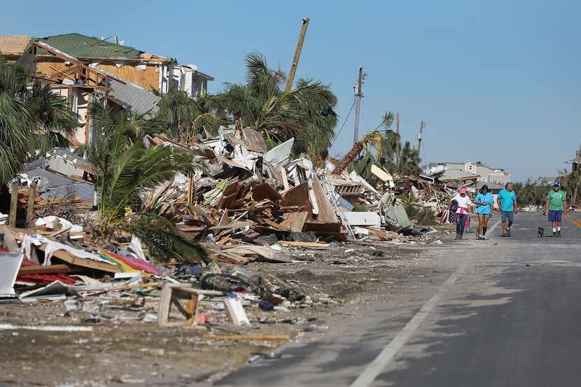 Homeowners walk along a debris strewn street after Hurricane Michael passed through Mexico...