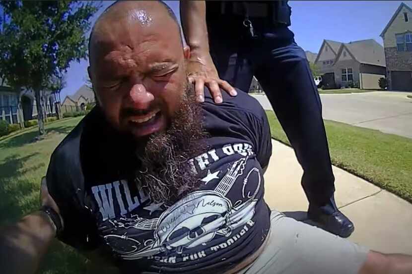 In this screen grab from police body-cam video, Marco Puente grimaces after being...