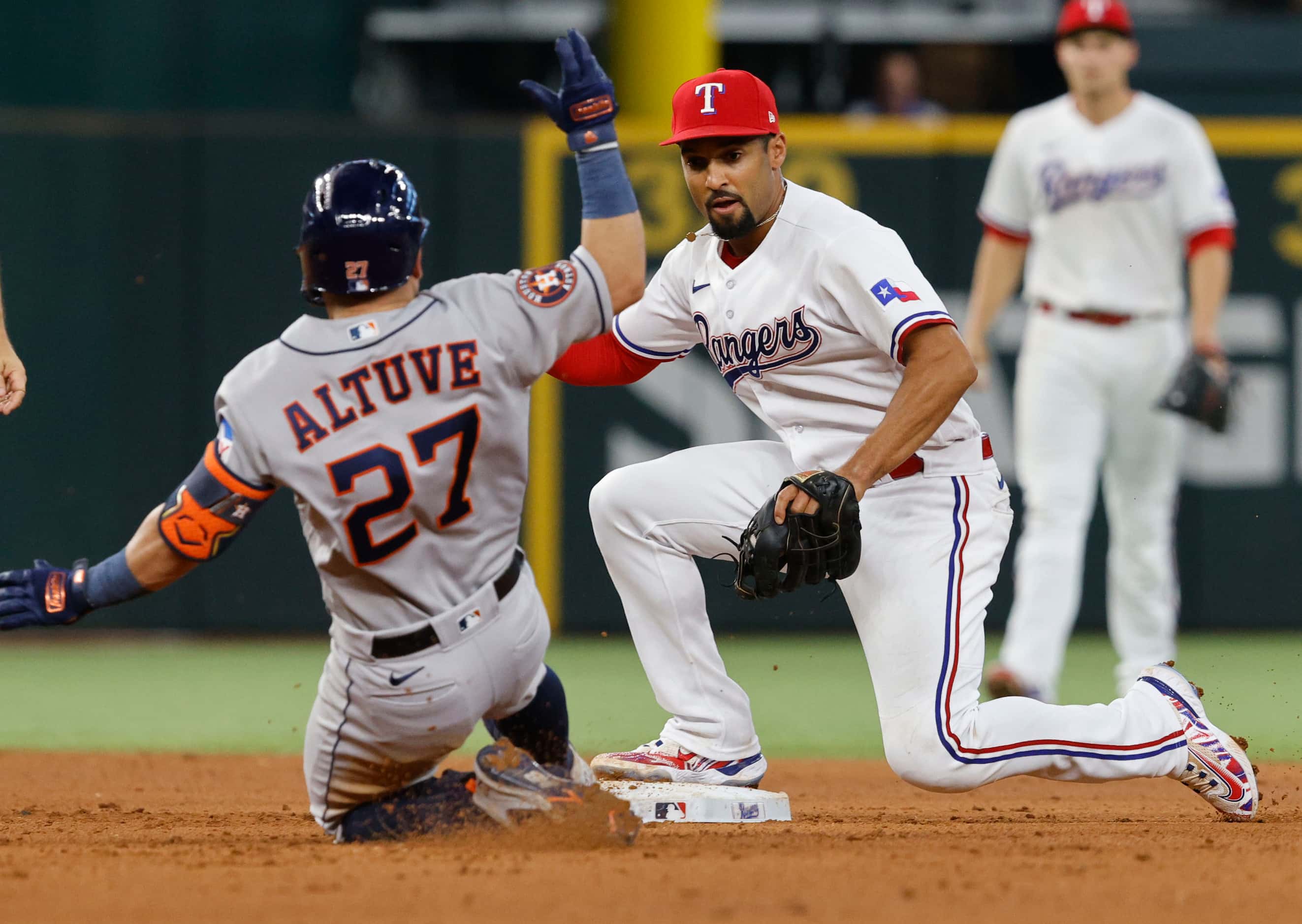 Houston Astros second baseman Jose Altuve (27) is tagged out by Texas Rangers second baseman...