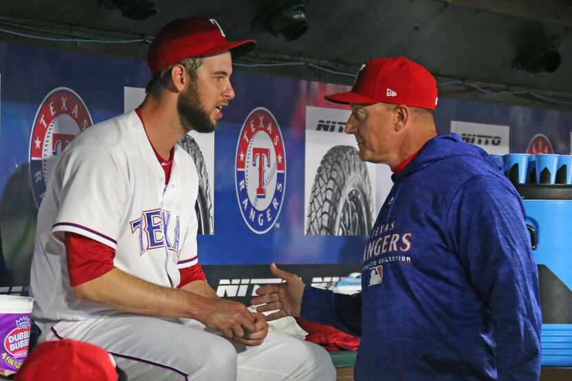 Texas Rangers manager Jeff Banister, right, talks with reliever Chris Martin (31) after his...