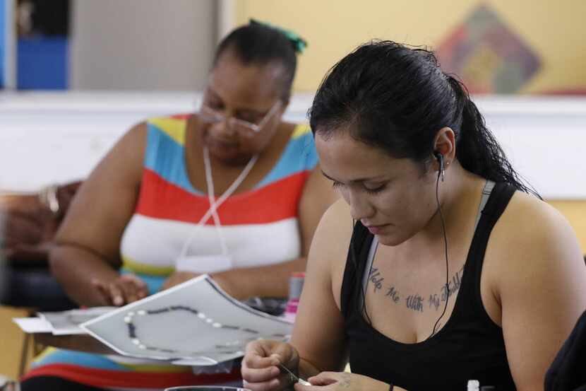 Yekitha Robinson (left) and Anastacia Duarte work with other women making jewelry at one of...