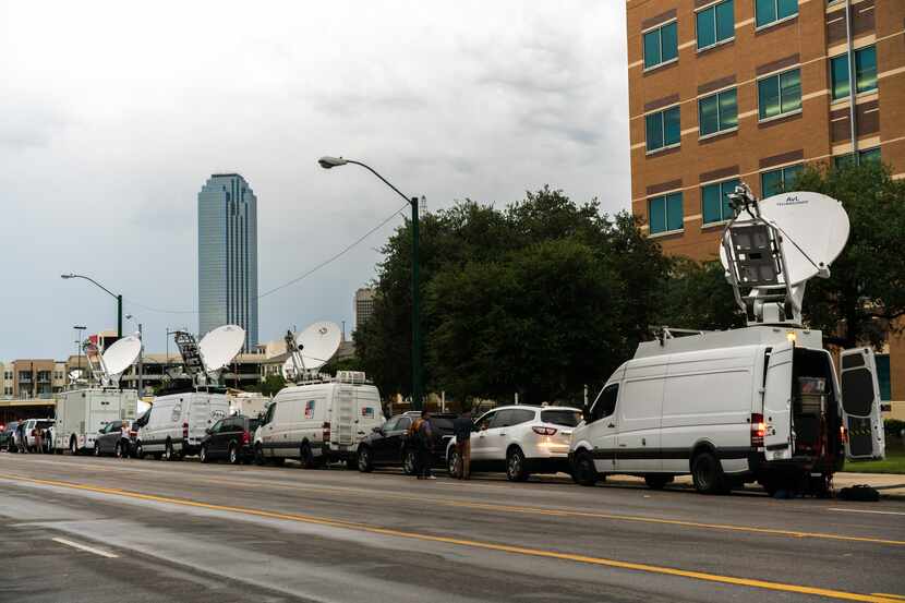 Media trucks line the streets of Dallas on Sunday,  July 10