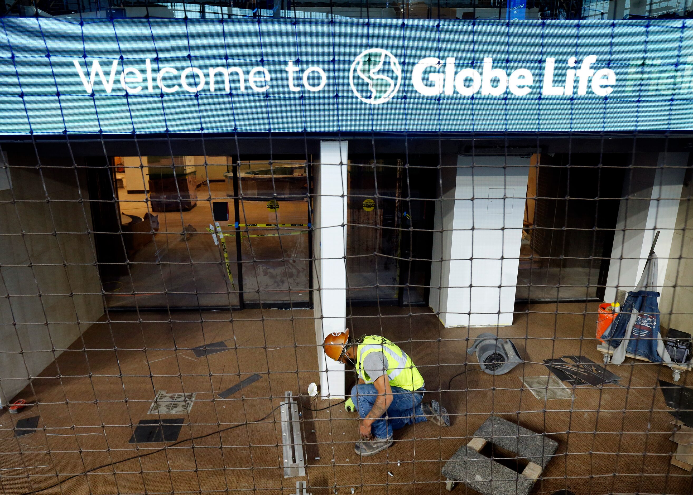 A construction worker installs a wall dividing field level suites behind home plate at the...