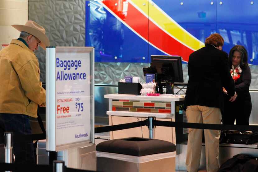 Southwest Airlines passenger Hugh Hubert (left) waits to check in at Dallas Love Field on...