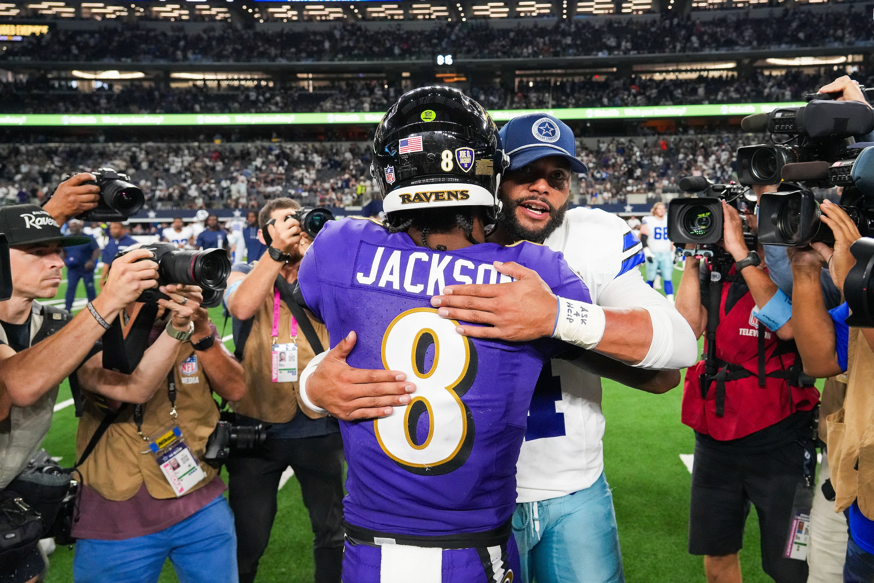 Dallas Cowboys quarterback Dak Prescott (4) hugs Baltimore Ravens quarterback Lamar Jackson...