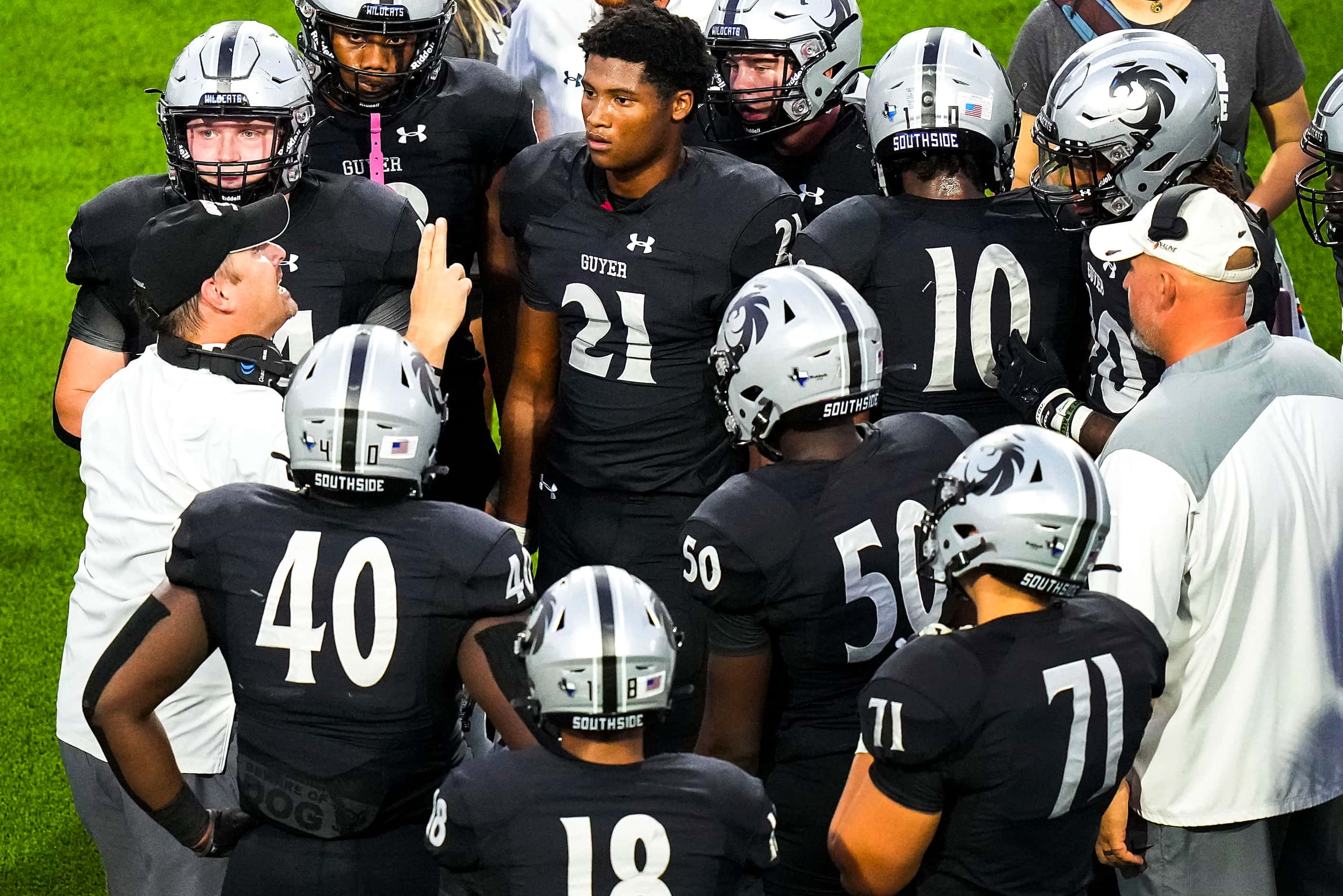 Denton Guyer players gather around head coach Reed Heim (left) during the first half of a...