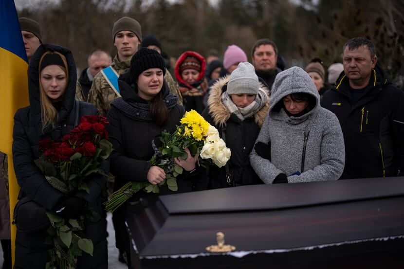 Relatives stand by the coffin of Eduard Strauss, a Ukrainian serviceman who died in combat...