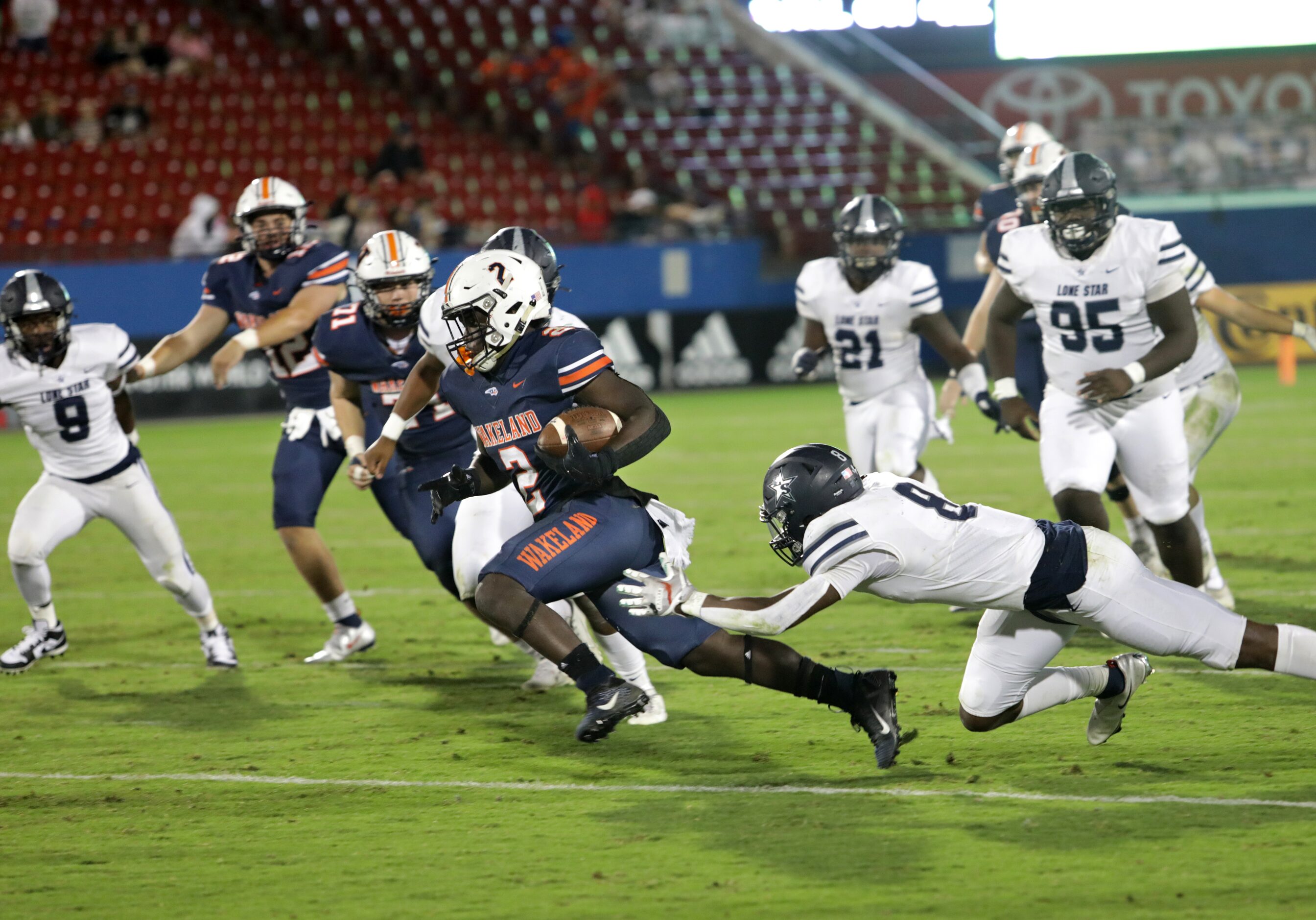 Wakeland player #2, Jared White, breaks past Lone Star player #8, Devin Turner, as he...