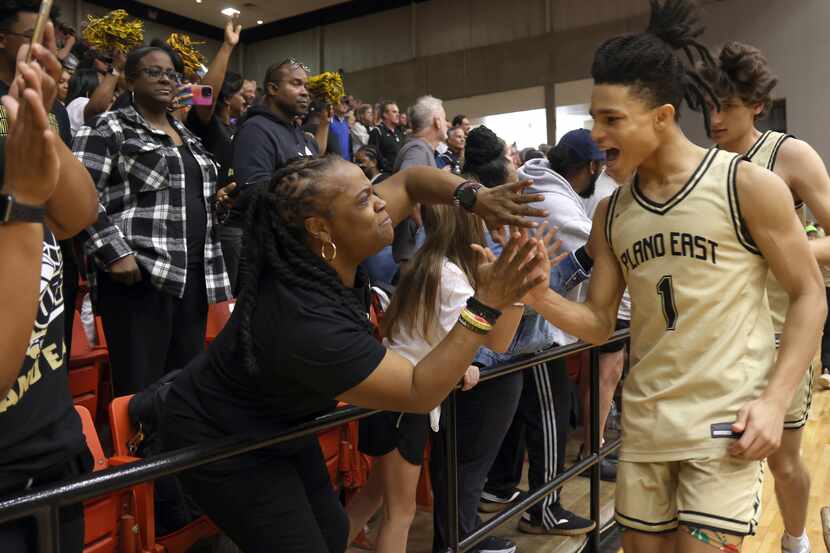 Plano East guard Richard Anton (1), right, celebrates with fans after the team's 76-60...