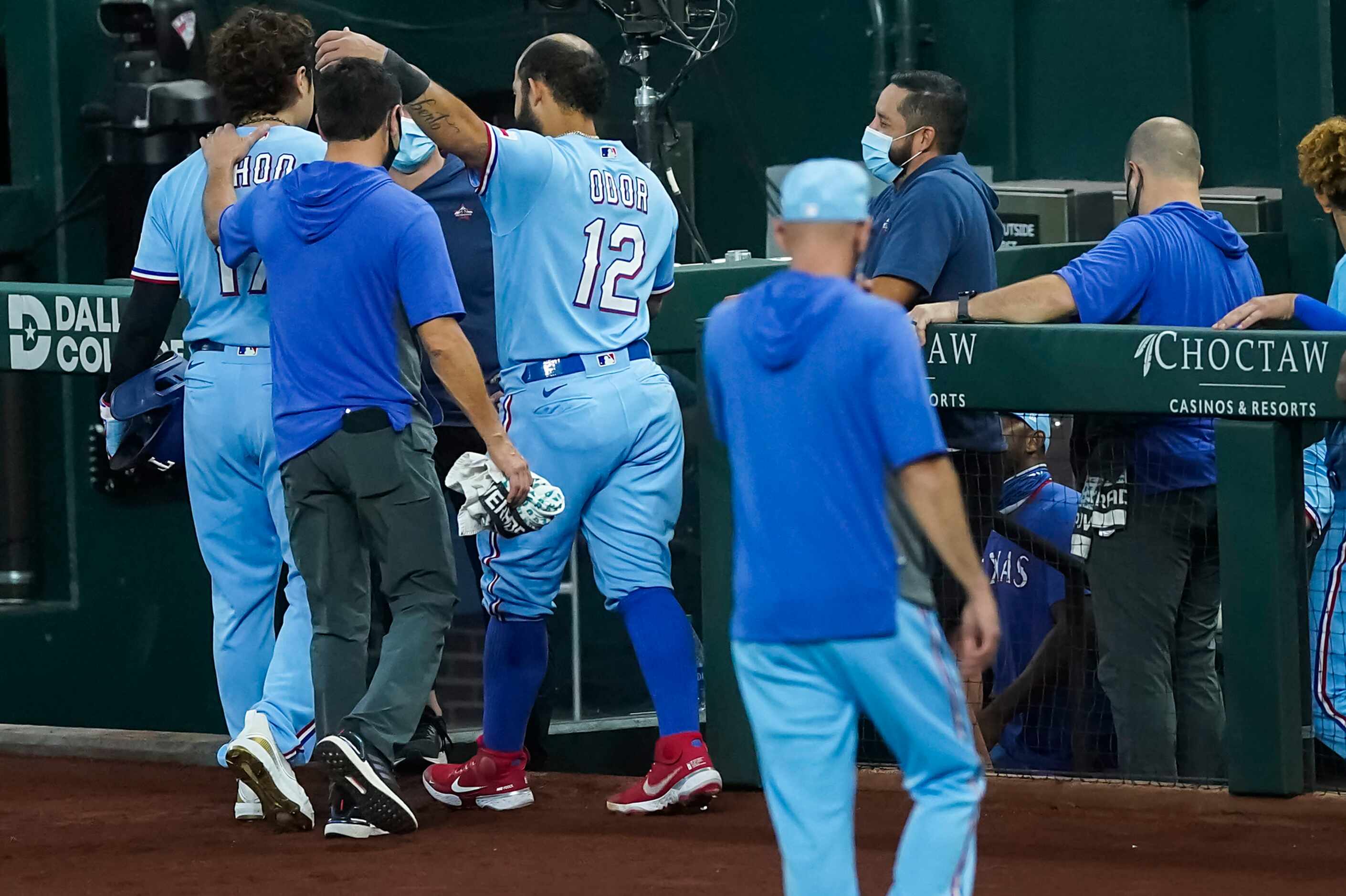 Texas Rangers designated hitter Shin-Soo Choo is welcomed back to the dugout with a hug from...