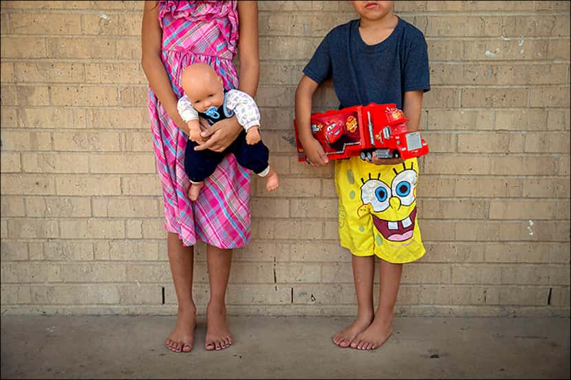 
Evelyn, 8, and her 5-year-old brother, Brian, clutch their favorite toys they have received...