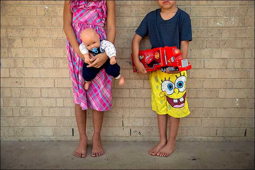 
Evelyn, 8, and her 5-year-old brother, Brian, clutch their favorite toys they have received...