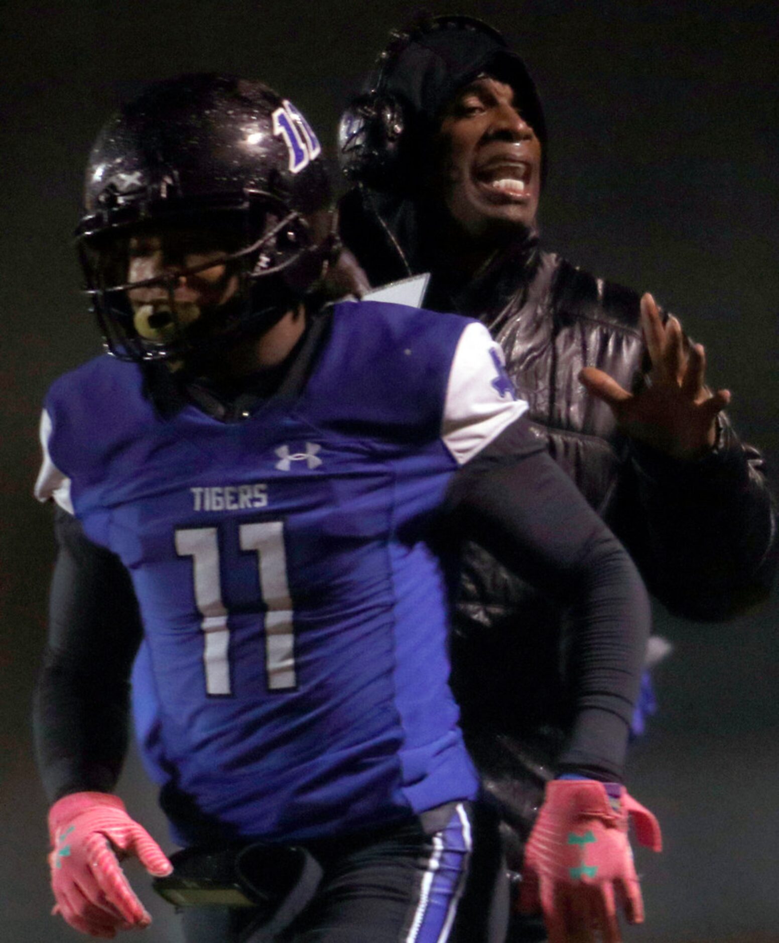 Trinity Christian-Cedar Hill offensive coordinator Deion Sanders speaks with members of his...