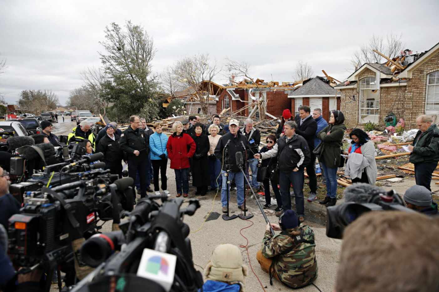 Garland Mayor Douglas Athas (center) addressed the media in a storm-damaged neighborhood...