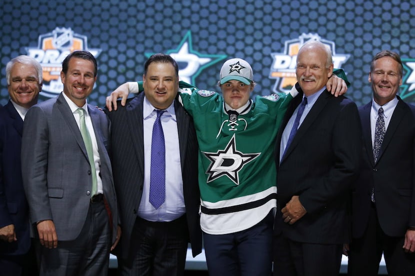 Julius Honka stands with Dallas Stars officials after being chosen 14th overall during the...