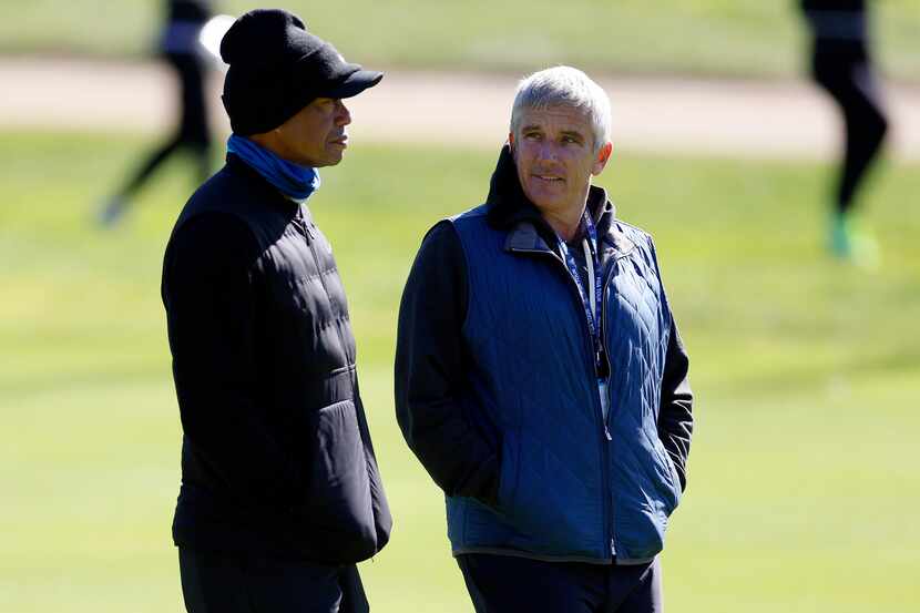 Tiger Woods, left, talks to PGA Commissioner Jay Monahan on the 15th hole during the pro-am...