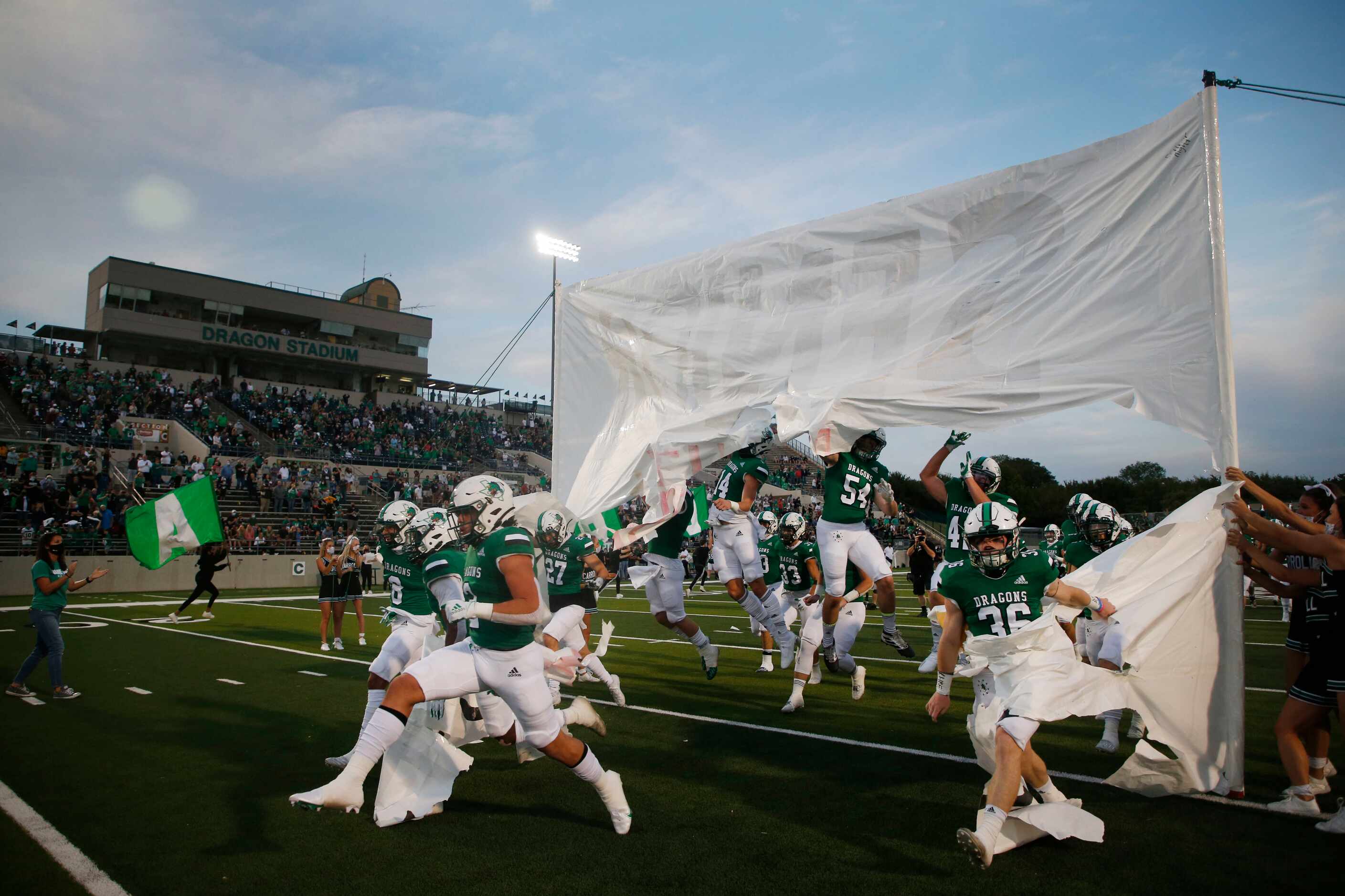 Southlake Carroll players break a banner as they enter the field prior to playing Rockwall...