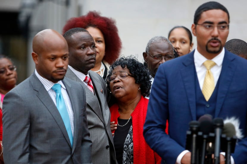 Judy Scott, Walter Scott's mother, is comforted by her son Rodney Scott as the family...