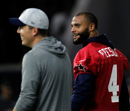 Dallas Cowboys quarterback Dak Prescott (4) shares a light moment with offensive coordinator...