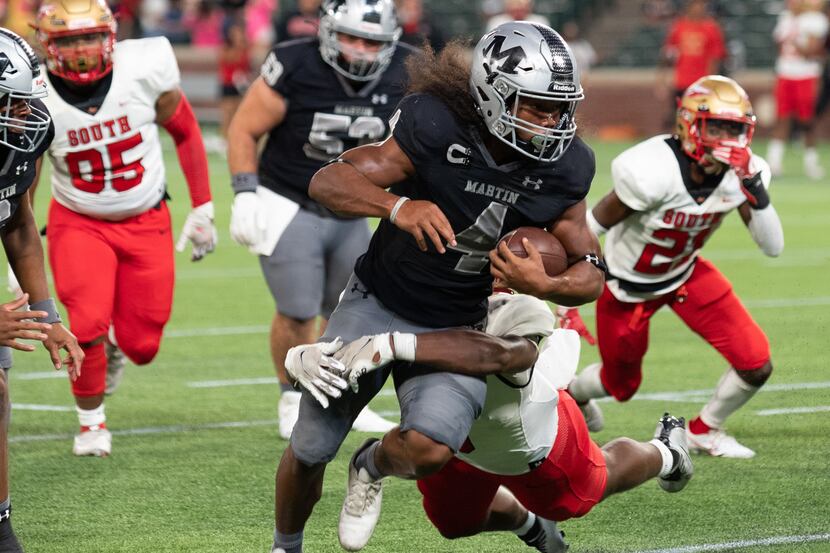 Arlington Martin senior wide receiver Michael Barrow (4) runs with the football for positive...