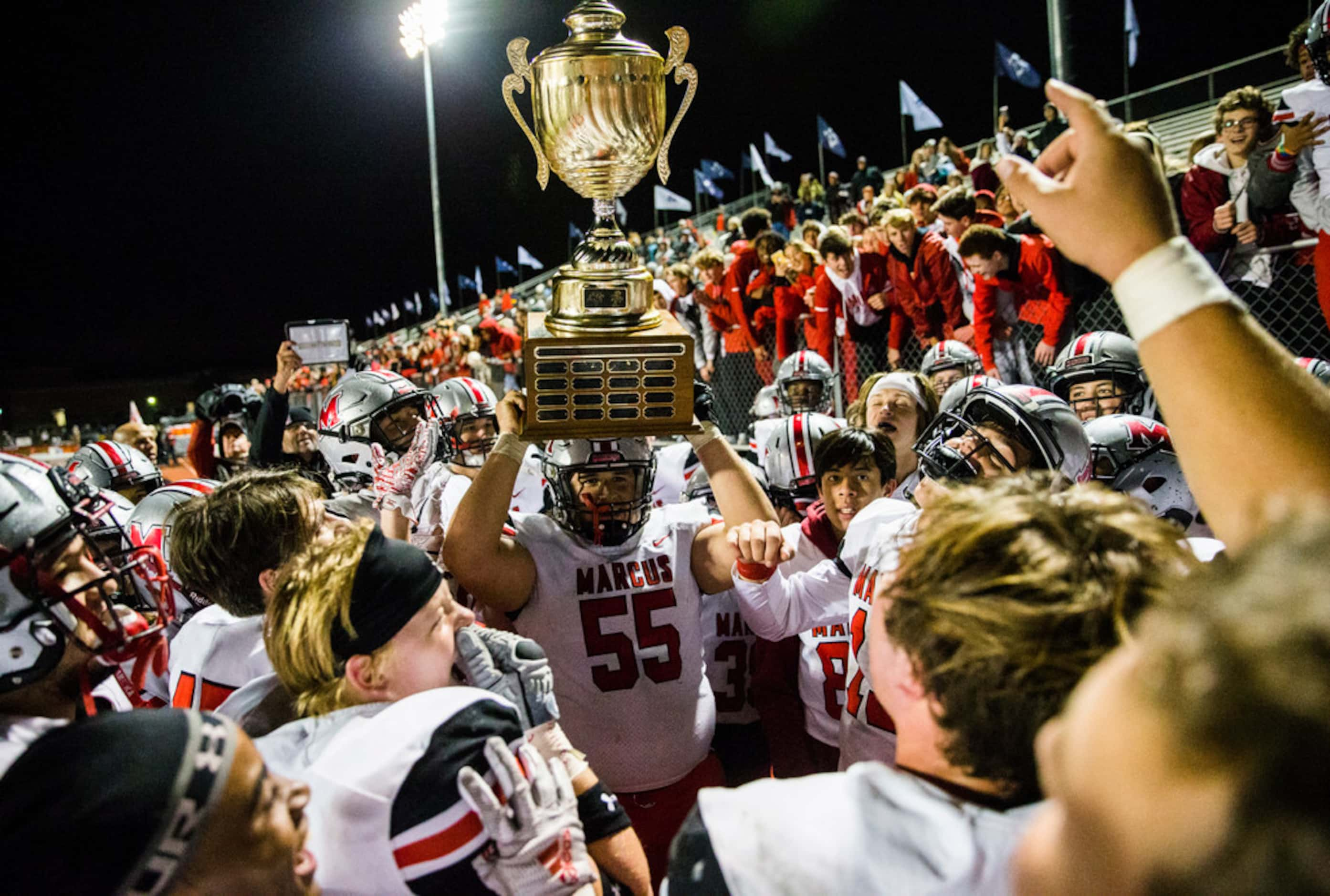 Flower Mound Marcus hoists the Mound Showdown trophy after a 34-31 win over Flower Mound on...