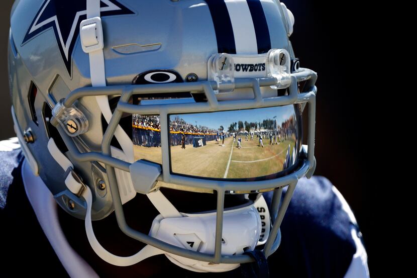 The playing field is reflected in the reflective face shield of Dallas Cowboys safety Jayron...