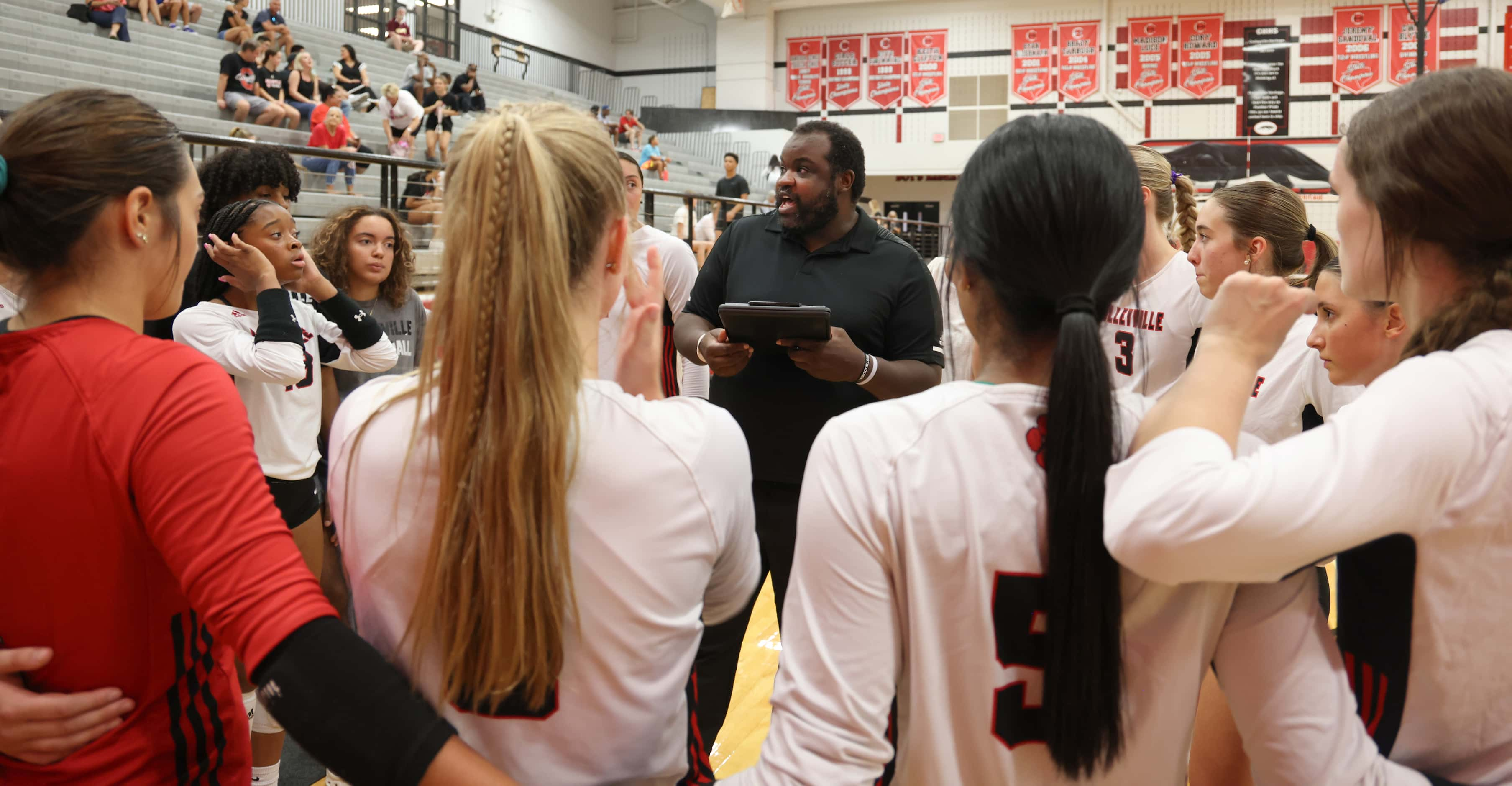 Colleyville Heritage head volleyball coach Josh McKinney, center, speaks with his players...