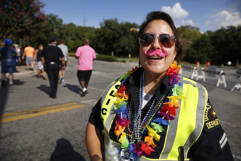 Dallas police Sr. Corporal Monica Almeida sports a pink mustache and beads as she controls...