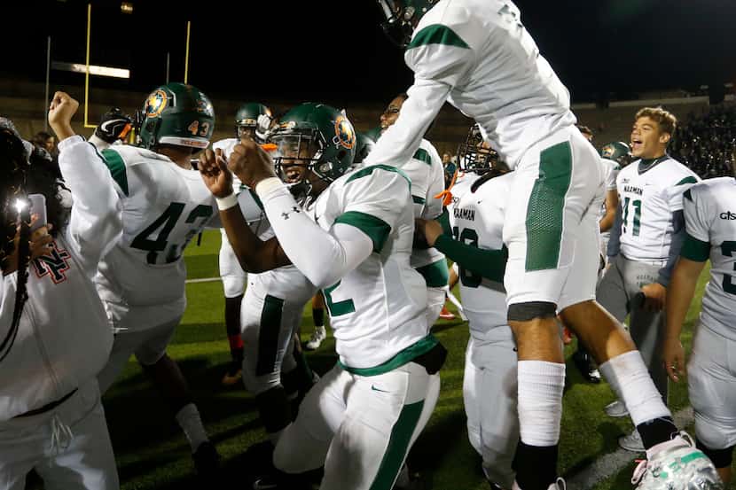 Naaman Forest players, including Shaft Davis (32), celebrate their 42-27 win over Lakeview...
